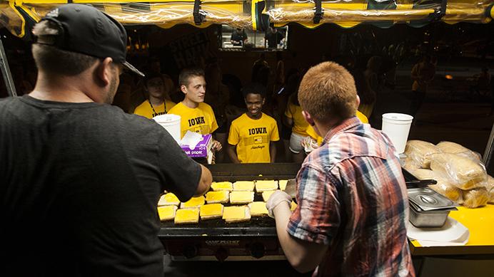 Marco’s employees serve first-year students during the OnIowa program on Madison Street on Aug. 18. Madness on Madison is an annual kickoff event for freshmen following the Kickoff at Kinnick, where they take their class photo on the field. The event offered free food, music, and inflatable activities. (Joseph Cress/The Daily Iowan)