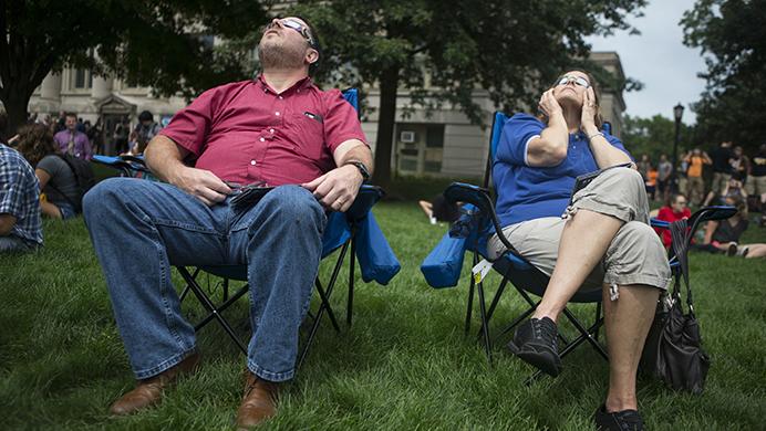 Locals Jim Jacobson and his wife, Irene Friend, observe the solar eclipse from the Pentacrest on Aug. 21. Jacobson is a former Cedar Rapids Gazette reporter who finished writing in 2002. He now works as an attorney for a local labor union. (Ben Smith/The Daily Iowan)