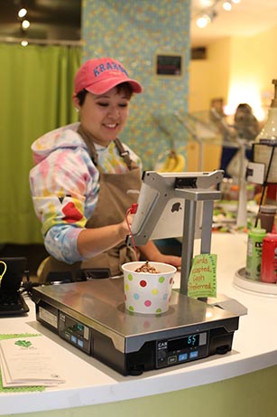 An employee at Yotopia Frozen Yogurt, 132 S. Clinton St., serves customers on Monday, August 21, 2017. Yotopia hosted an event in sponsorship of Bur Oak Land Trust. (Elle May/The Daily Iowan)