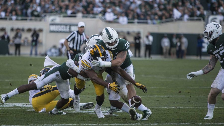 Iowa wide receiver Brandon Smith (12) attempts to recover a fumble forced by Michigan State's Joe Bachie during the game between Iowa and Michigan State at Spartan Stadium on Saturday, Sept. 30, 2017. The Hawkeyes fell to the Spartans with a final score of 10-17. (Ben Smith/The Daily Iowan)