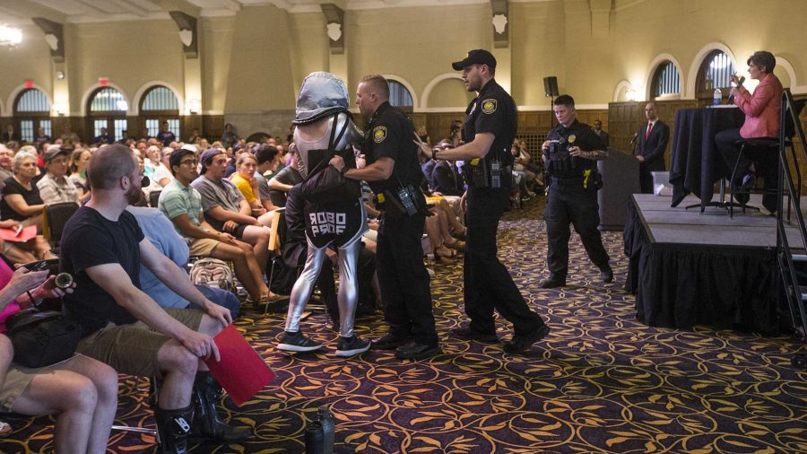 University of Iowa police escort a protestor during a town hall meeting in the IMU on Friday, Sept. 22, 2017. While Sen. Ernst spoke in the IMU, a protest was held outside in Hubbard Park. (Joseph Cress/The Daily Iowan)