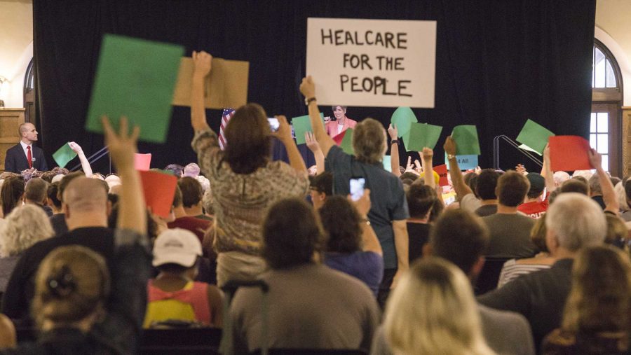 Participants display their signs in protest to Senator Joni Ernsts policy proposal at a Town Hall meeting in the Iowa Memorial Union on Friday, Sept. 22, 2017. (James Year/The Daily Iowan)