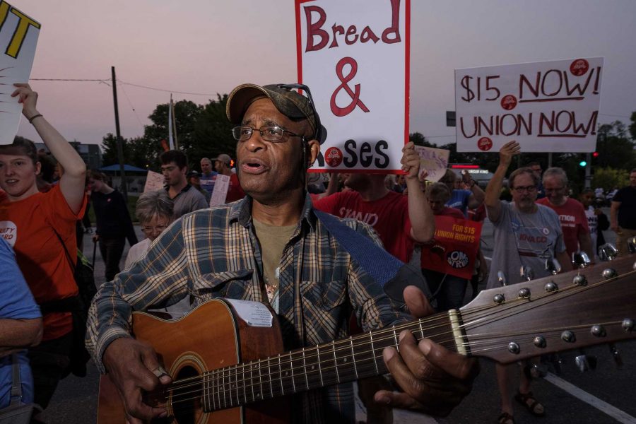 A protestor plays guitar during a march in Des Moines on Monday September, 4 2017. Protestors attended multiple events in Des Moines on Labor Day in order to demonstrate in support of a fifteen dollar per hour minimum wage and private sector unions. (Nick Rohlman)