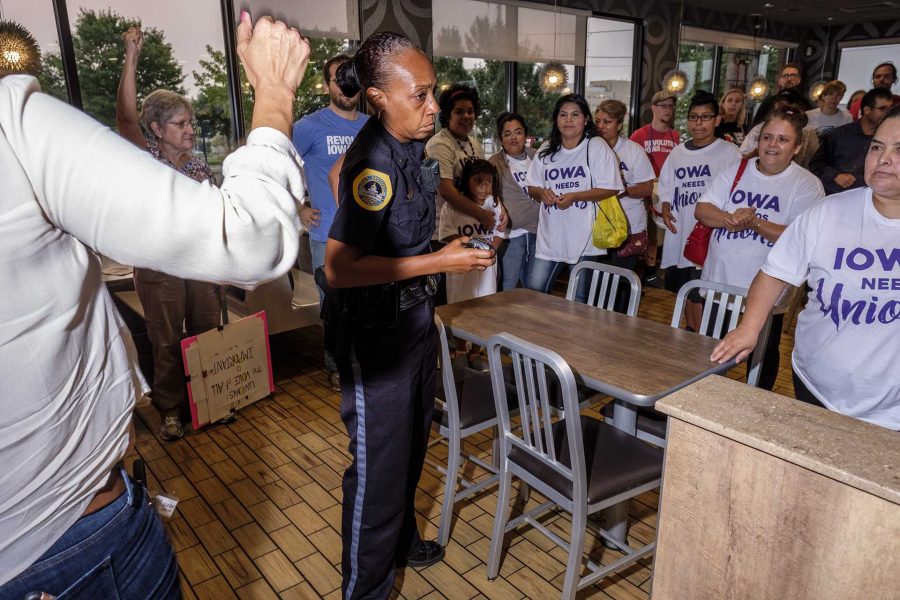 A Des Moines police officer attempts to remove protestors from a McDonalds in Des Moines on Monday September, 4 2017. Protestors attended multiple events in Des Moines on Labor Day in order to demonstrate in support of a fifteen dollar per hour minimum wage and private sector unions. (Nick Rohlman/The Daily Iowan)