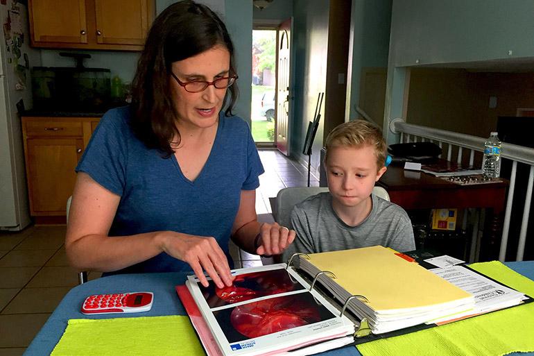 Ann Pipes and her 11-year-old son, Winslow, go over Winslow's medical records and aid his public school is required to give him through the Americans with Disabilities Act. Winslow has a craniofacial disorder and severe hearing loss he was born with. Winslow depends on Medicaid coverage for his care, which has included 14 surgeries starting when he was an infant. (Lisa Gillespie/Kaiser Health News/TNS)