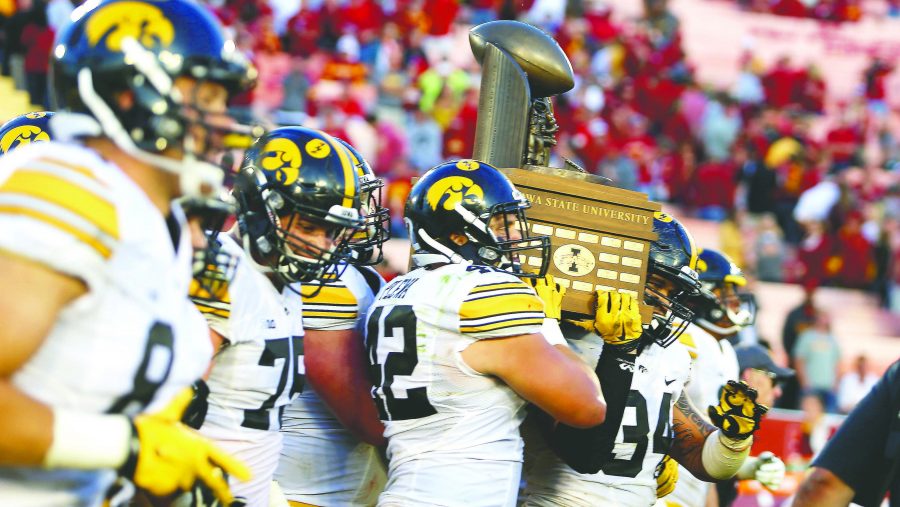 Iowa players walk towards Iowa fans with the Cy-Hawk Trophy after the Cy-Hawk Series game against Iowa State in Jack Trice Stadium in Ames, Iowa on Sept. 12, 2015. The Hawkeyes defeated the Cyclones, 31-17. (The Daily Iowan/ Alyssa Hitchcock)