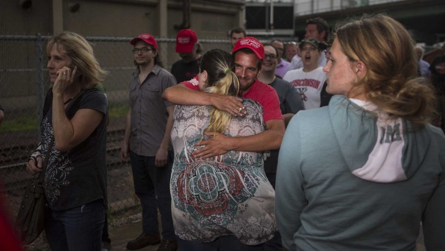 A rally protester and Trump supporter embrace outside the U.S. Cellular Center in Cedar Rapids for a Trump Rally on Wednesday, June 21. Before President Trump arrived, the venue reached capacity, leaving rally members, outside in the rain.  (Ben Smith/The Daily Iowan)