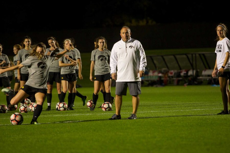 Iowa head coach Dave Diiani helps his team warm up at the Iowa Soccer Complex in Iowa City on Saturday, October 21, 2017. The Hawkeyes fell to the Badgers 3-0 (Paxton Corey/The Daily Iowan)
