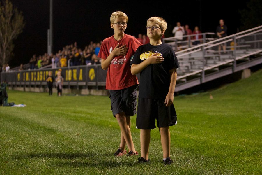 Two young soccer fans stand at attention for the national anthem at the Iowa Soccer Complex in Iowa City on Saturday, October 21, 2017. The Hawkeyes fell to the Badgers 3-0 (Paxton Corey/The Daily Iowan)