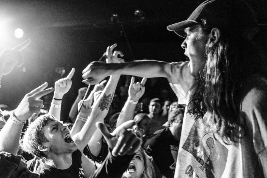 Fans scream into Knocked Loose lead singer Bryan Garris' microphone during a concert at Blue Moose on Saturday October 21, 2017. Knocked Loose is a hardcore punk band from Kentucky (Nick Rohlman/The Daily Iowan)