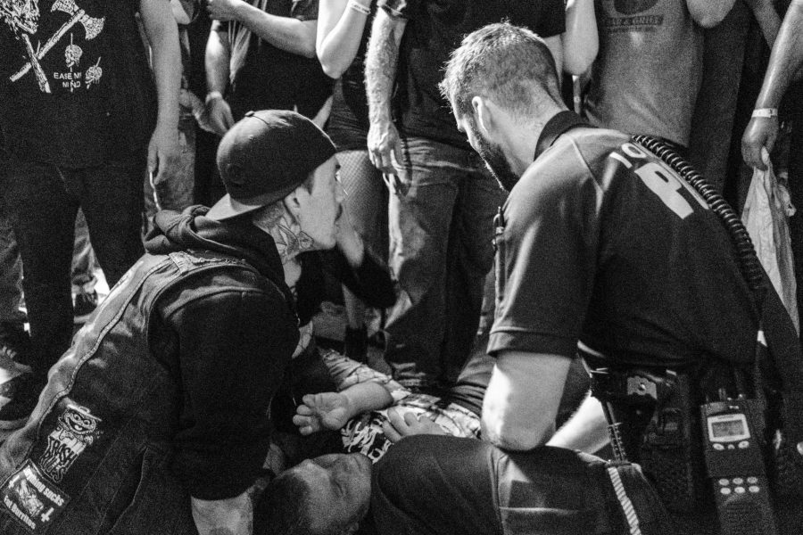 A concertgoer and ICPD officer provide assistance to a man after he was injured jumping from the stage during a concert at Blue Moose on Saturday October 21, 2017. the injured fan was eventually able to walk out of the show. (Nick Rohlman/The Daily Iowan)