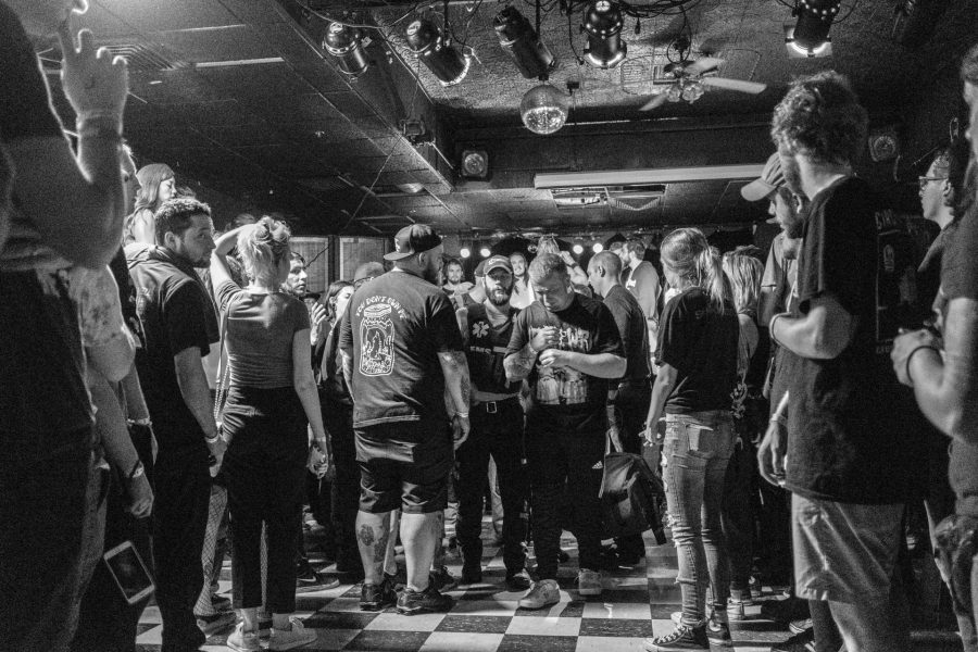 A man who was injured jumping from the stage walks towards the exit with medical first responders during a concert at Blue Moose on Saturday October 21, 2017. The fan was able to leave with minimal assistance after appearing to sustain a head injury in the accident (Nick Rohlman/The Daily Iowan)