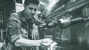 Bread Garden employee Sean McKinney cleans the espresso machine at the coffee bar on Monday, Oct. 23, 2017. Bread Garden serves coffee until 9 p.m. (Nick Rohlman/The Daily Iowan)