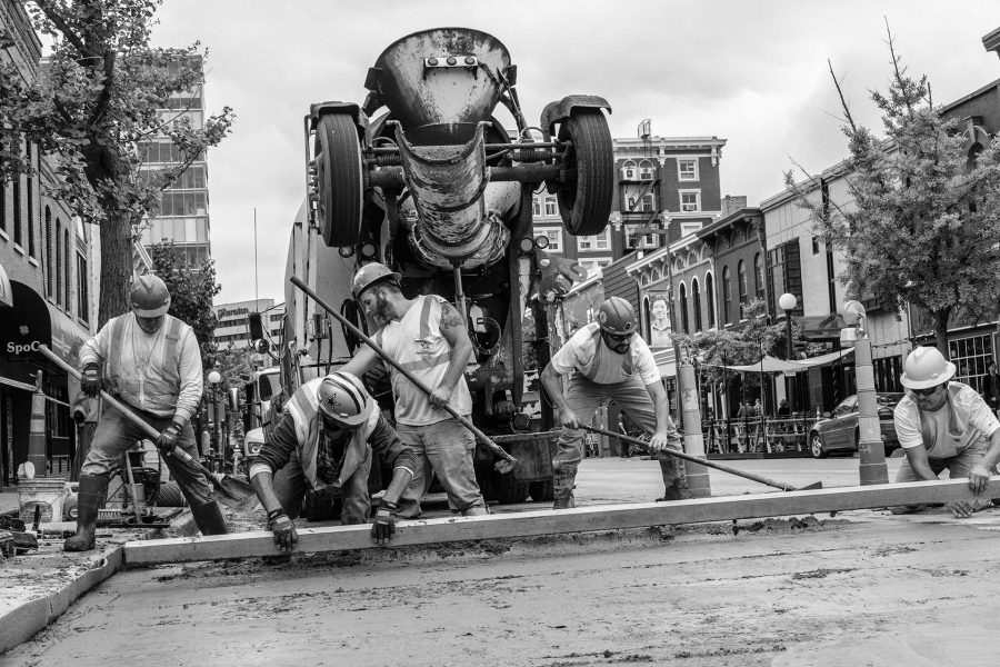 Construction workers lay concrete on Dubuque St. on Thursday, Oct. 12, 2017. This week construction crews worked on a project completing the installation of fiber optic internet cables which will allow up to 300 businesses to have access to internet with speeds ranging from 50 to 300 mb/s. (Nick Rohlman/The Daily Iowan)