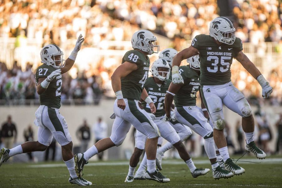 Michigan state defenders Weston Bridges (27) Kenny Willekes (48) and Joe Bachie (35) celebrate after forcing a turnover during the game between Iowa and Michigan State at Spartan Stadium on Saturday Sept. 30, 2017. The Spartans defeated the Hawkeyes 17-10. (Nick Rohlman/The Daily Iowan)