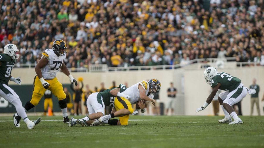 Iowa quarterback Nate Stanley is tackled for a loss during the game between Iowa and Michigan State at Spartan Stadium on Saturday Sept. 30, 2017. The Spartans defeated the Hawkeyes 17-10. (Nick Rohlman/The Daily Iowan)