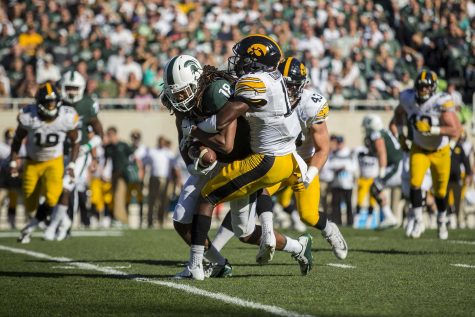 Iowa cornerback Michael Ojemudia tackles Michigan State wide receiver Felton Davis during the game between Iowa and Michigan State at Spartan Stadium on Saturday Sept. 30, 2017. The Spartans defeated the Hawkeyes 17-10. 