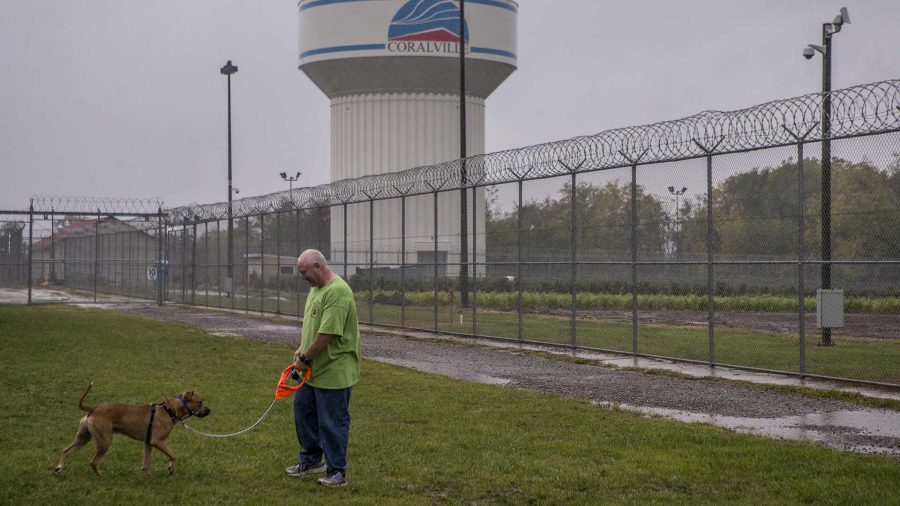 Terry, an inmate volunteer, on Tuesday walks Russ, a shelter dog who was placed at the Iowa Medical & Classification Center as part of a program in which inmates teach shelter dogs obedience and help to rehabilitate them for adoption or placement. (Nick Rohlman/The Daily Iowan)