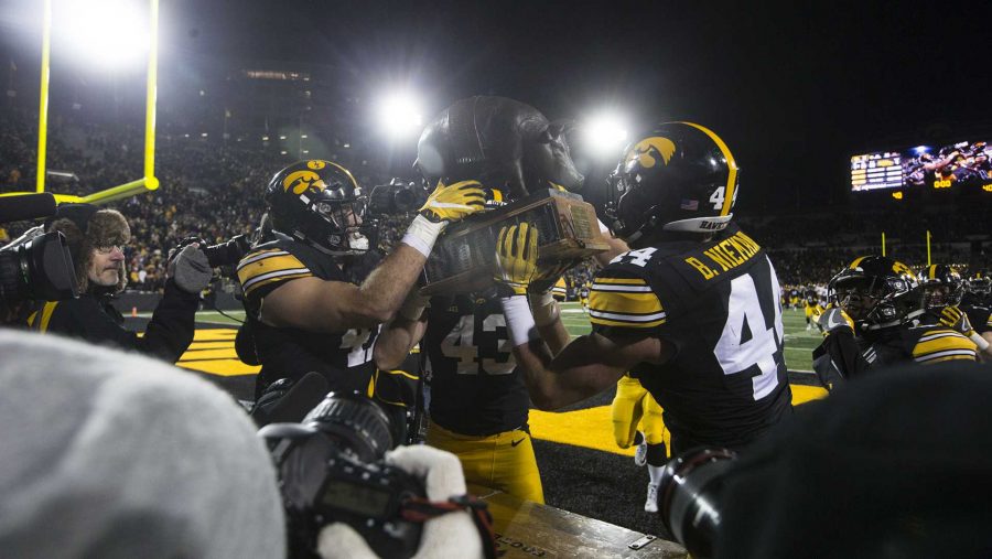 Iowa linebackers Bo Bower, Josey Jewell, and Ben Niemann lift the Floyd of Rosedale trophy after an Iowa/Minnesota football game in Kinnick Stadium on Saturday, Oct. 28, 2017. The Hawkeyes defeated the Golden Gophers, 17-10. (Joseph Cress/The Daily Iowan)