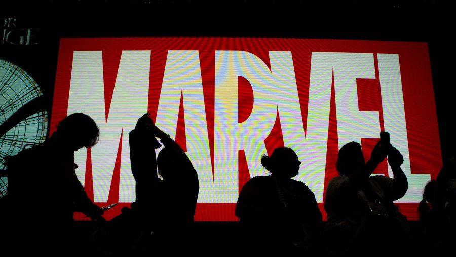 Attendees sit in front of an illuminated Marvel sign during the second day of Comic-Con 2016 on July 21, 2016 in San Diego. (Harrison Hill/Los Angeles Times/TNS)