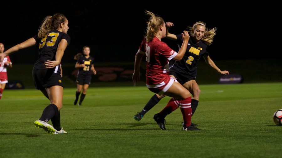 Cory Burns (left) and Laura Lainson (right) pursue the ball against Emily Borgmann at the Iowa Soccer Complex in Iowa City on Saturday, October 21, 2017. The Hawkeyes fell to the Badgers 3-0 (Paxton Corey/The Daily Iowan)