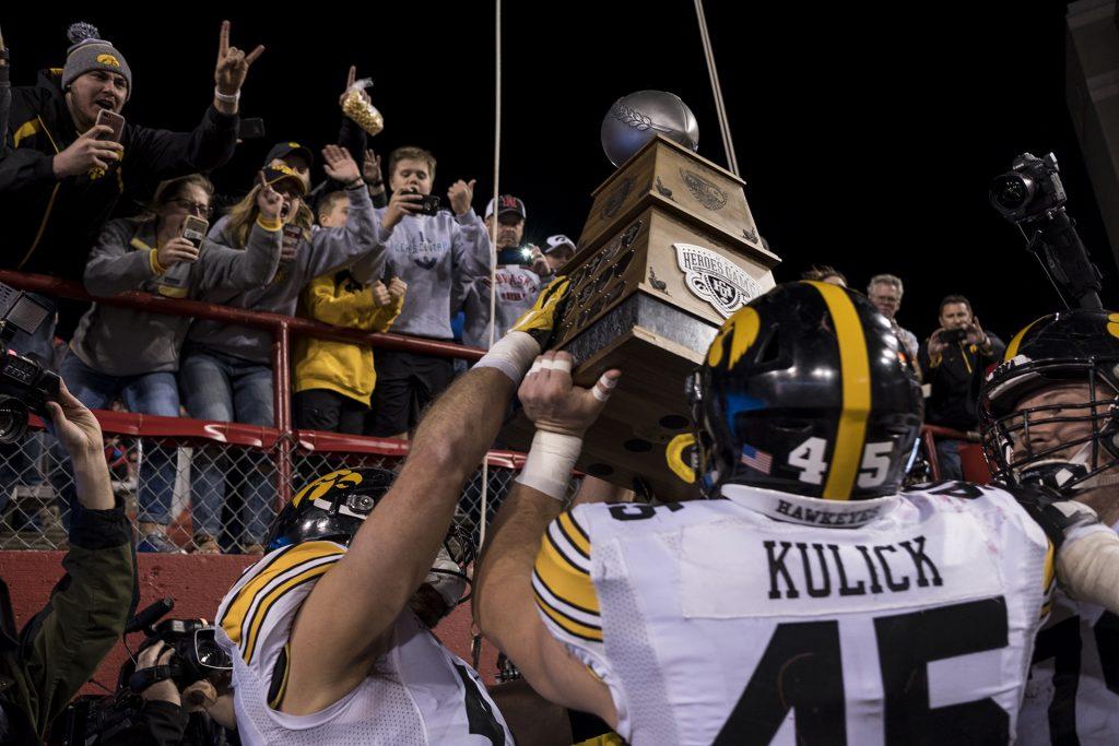 Iowa players lift the Hero's trophy after Iowa's game against Nebraska at Memorial Stadium on Friday, Nov. 24th, 2017. The Hawkeyes defeated the Cornhuskers 56-14. (Nick Rohlman/The Daily Iowan)