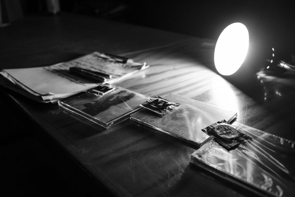 Condoms and cds are placed on the merch table for sale while Fiona Grey performs at the Yacht Club in Iowa City on Thursday, Nov. 30, 2017. (Nick Rohlman/The Daily Iowan)