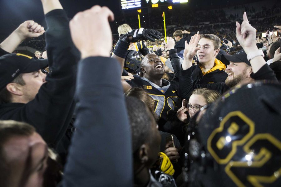 Fans celebrate with Iowa offensive linemen James Daniels while storming the field during the Iowa/Ohio State football game in Kinnick Stadium on Saturday, Nov. 4, 2017. The Hawkeyes defeated the Buckeyes in a storming fashion, 55-24. (Joseph Cress/The Daily Iowan)