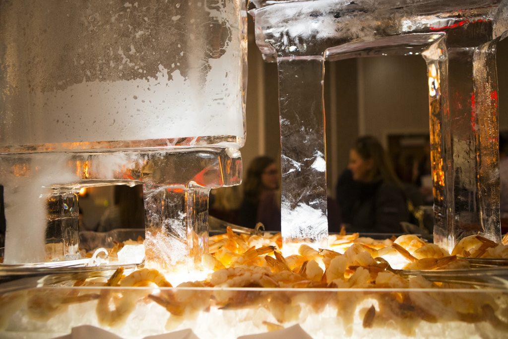 Shrimp is displayed below an ice sculpture during a ribbon cutting event for the Hilton Garden Inn on Clinton Street on Thursday, Nov., 30, 2017. The 12th floor of the hotel features a rooftop bar and restaurant that is open to the public. The hotel opened in October. (Joseph Cress/The Daily Iowan)