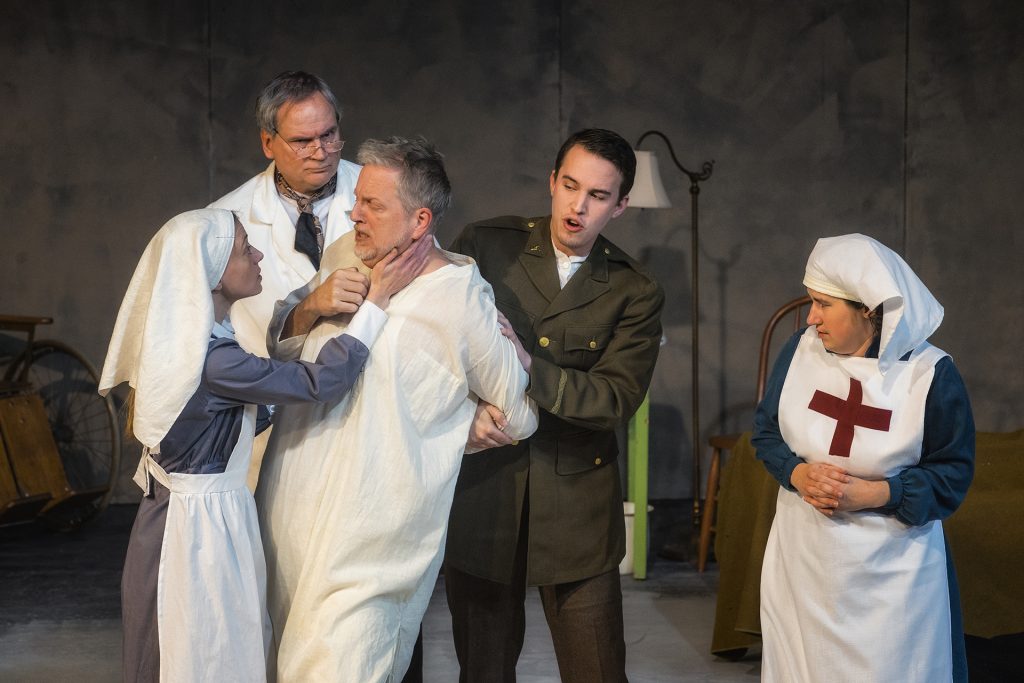 Actors, as medical professionals, help calm a shell-shocked patient during a dress rehearsal for the play Shell Shocked on Wednesday, Dec. 13, 2017. The performance centers on a doctor's search to understand and improve conditions on the Western Front during World War 1. (James Year/The Daily Iowan)