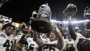 Iowas Kevin Ward (26) holds up the New Era Pinstripe Bowl trophy after the Hawkeyes beat Boston College in the Pinstripe Bowl at Yankee Stadium in New York on Wednesday, Dec. 27. The Hawkeyes went on to win 27-20. 