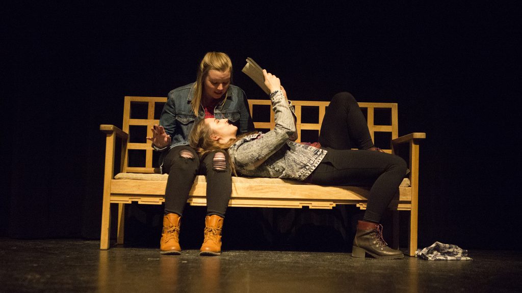 Junior+Kaylyn+Kluck%2C+playing+Sarai%2C+reads+a+book+as+her+girlfriend+Iris%2C+played+by+sophomore+Emilia+Bendler+watches+during+a+dress+rehearsal+of+Western+Tinder.+This+student+written+and+directed+play+examines+homosexuality+and+intolerance+in+small+town+Wyoming.+%28Katie+Goodale%2FThe+Daily+Iowan%29