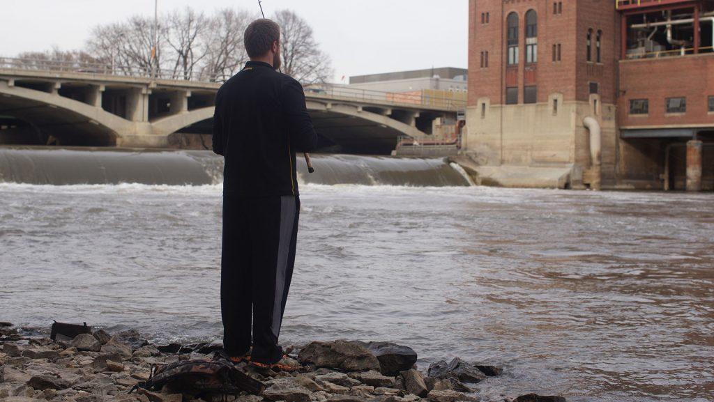 Andy DeCamp a freshman at The University of Iowa fishes at the base of the Iowa River dam on, Tuesday March 22, 2016. The first day of the spring season was Sunday March 20, the day before students returned from spring break. (The Daily Iowan/Jordan Gale)