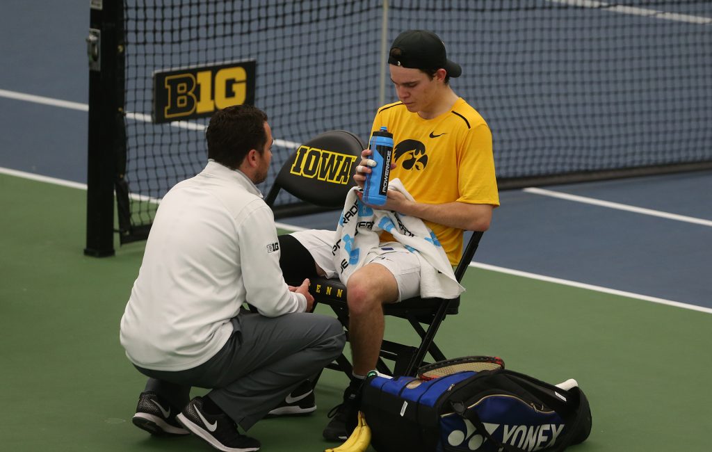 Iowa head coach Ross Wilson talks to his player Jonas Larsen during the Iowa-Utah match at the Hawkeye Indoor Tennis and Recreation Complex on Friday, March 3, 2017. The Hawkeyes defeated the Utes, 4-3. (The Daily Iowan/Margaret Kispert)