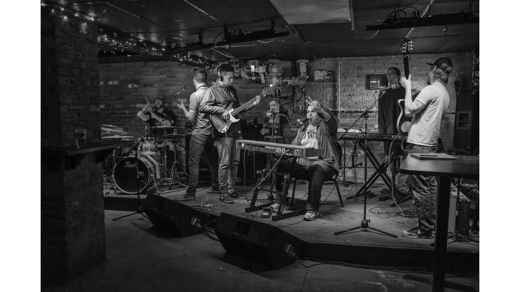 Volcalist and keyboardist Derek Thorn and the house band close out The Jam at the Yacht Club in Iowa City on Thursday, Jan. 25, 2018. Every thursday, Thorn, who performs under the stage name MC Animosity, assebles a house band from various local artistis and hosts a jam session where local artists can get experience playing with a full band. The group plays a variety of genres in a loose improvisational format. Thorn said he enjoys hosting the event because “Music is like a language, I like to think we get a bunch of guys on stage and talk together.” (Nick Rohlman/The Daily Iowan)