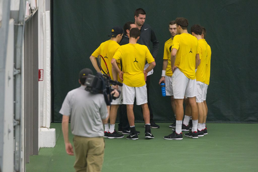 Iowa players meet with head coach Ross Wilson between matches during the Iowa/Creighton tennis match at the Hawkeye Tennis and Recreation Complex on Friday, Feb. 16, 2018. The Hawkeyes defeated the Bluejays, 7-0. 