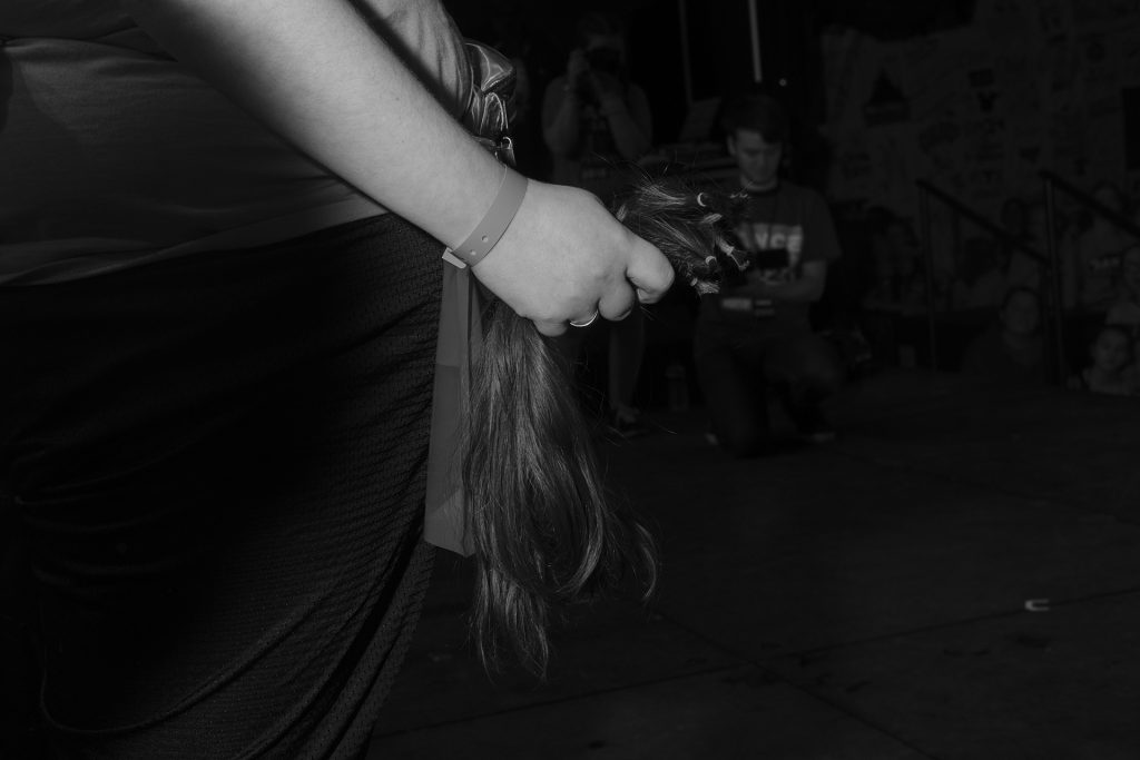 A participant hold their hair after their head was shaved during Dance Marathon at the Iowa Memorial Union on Saturday, Feb. 3, 2018. (Nick Rohlman/The Daily Iowan)