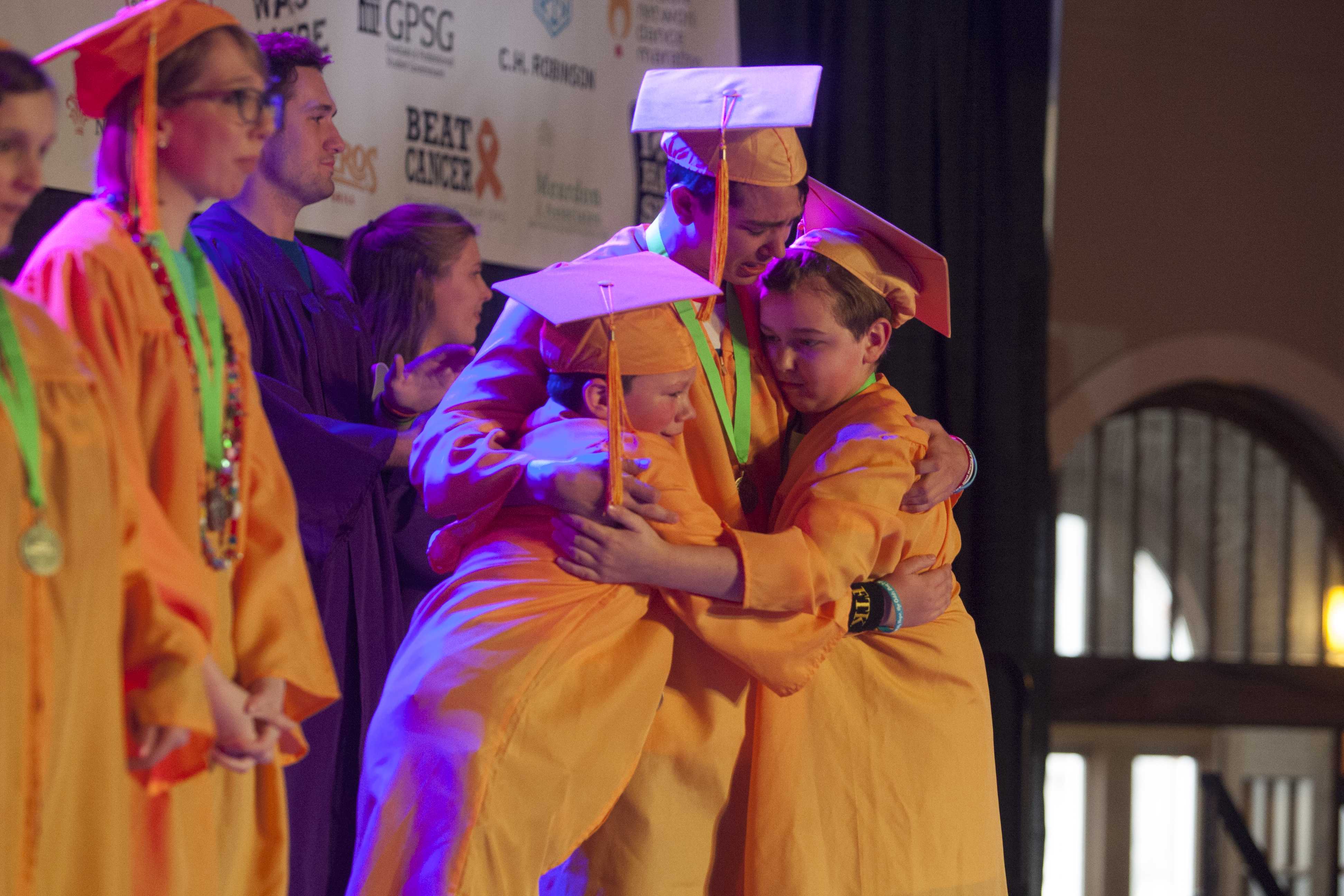 Friends share emotional hug as they take the stage together for graduation during UI Dance Marathon 24 at the IMU on Saturday, Feb. 3, 2018. (Katie Goodale/The Daily Iowan)