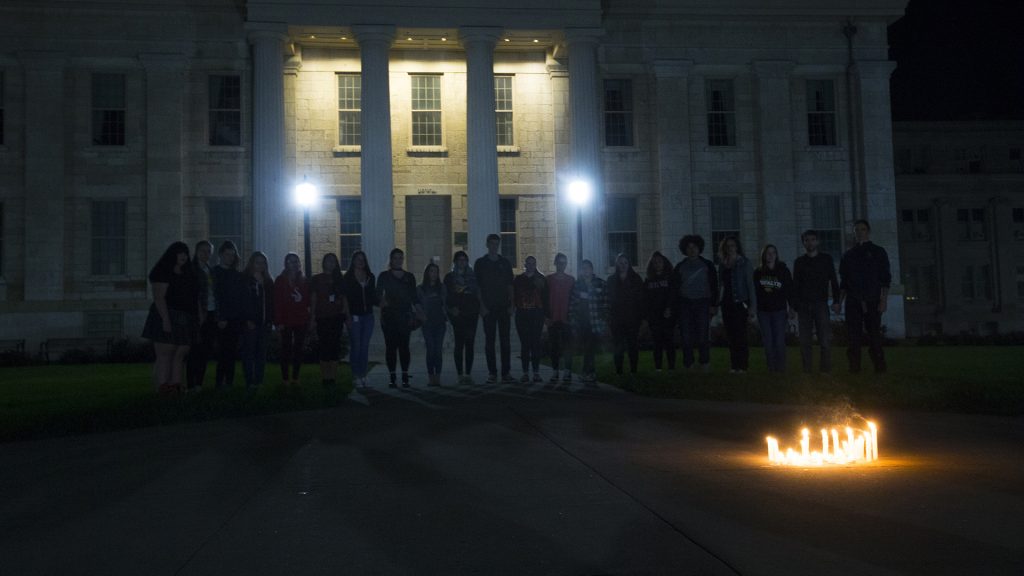 Survivors and allies hold hands during the UI Sister Vigil for Survivors of Campus Sexual Assault on the Pentacrest on Tuesday, Oct. 17, 2017. The event included letter writing to Iowa senators and the signing of thank you state of Iowa flags to senators fighting the withdrawal of Title IX protections for survivors of sexual assault. (Lily Smith/The Daily Iowan)