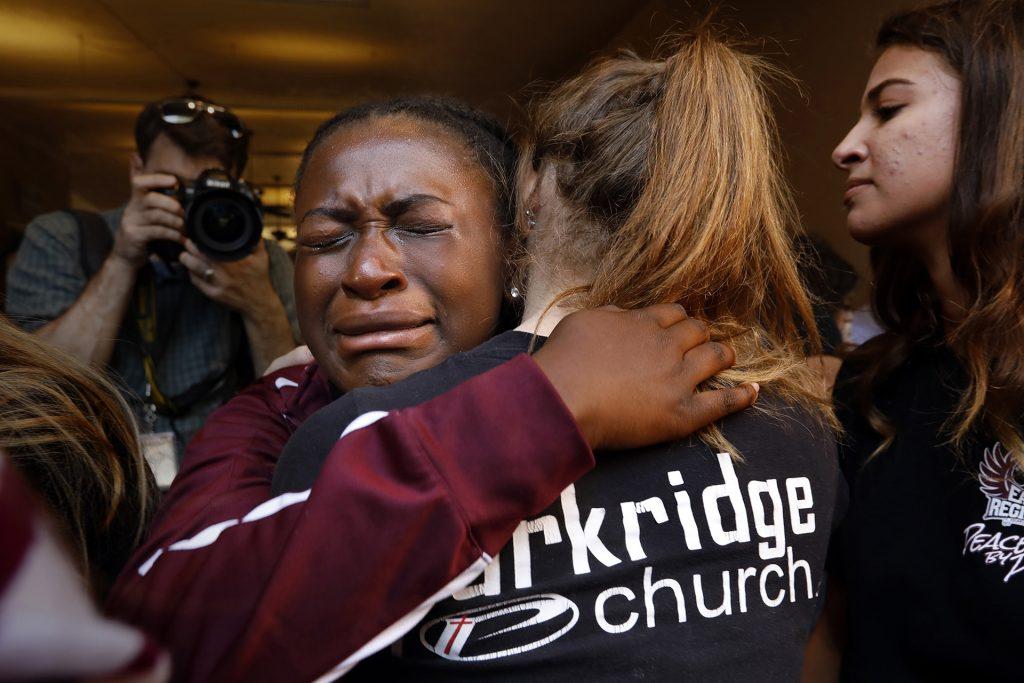 Marla Eveillard, 14, grieves with friends before the start of the community prayer vigil on Thursday, Feb. 15, 2018, one day after the deadly shooting at Marjory Stoneman Douglas High School in Parkland, Fla. that left 17 dead and 14 injured. (Carolyn Cole/Los Angeles Times/TNS)