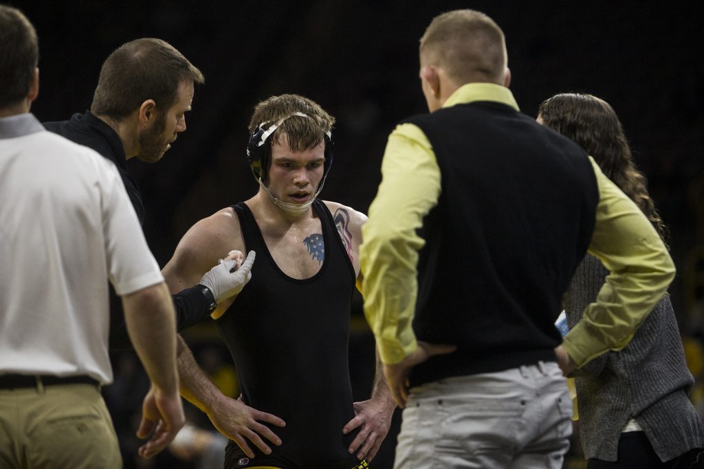 Iowa athletic trainers evaluate #2 ranked 149 pound Brandon Sorenson during the Iowa vs. Northwestern dual meet on Sunday, Feb. 4, 2018. The Hawkeyes defeated the wildcats 33-2. (Nick Rohlman/The Daily Iowan)