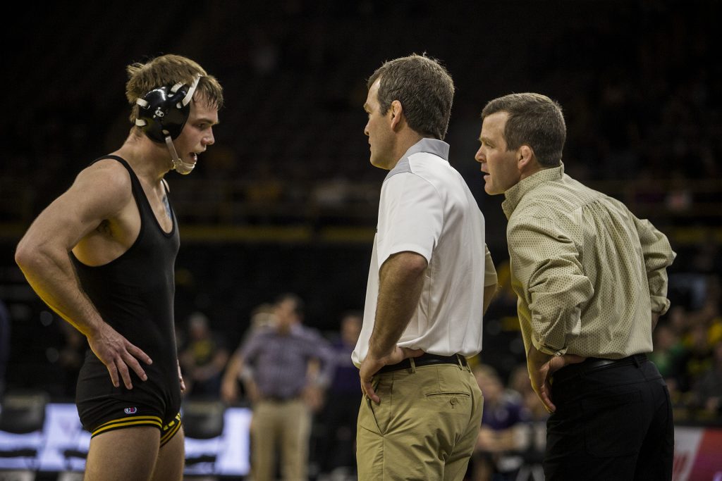 Iowa Head Coaches Tom and Terry Brands speak with #2 ranked 149 pound wrestler Brandon Sorenson during the Iowa vs. Northwestern dual meet on Sunday, Feb. 4, 2018. The Hawkeyes defeated the wildcats 33-2. (Nick Rohlman/The Daily Iowan)