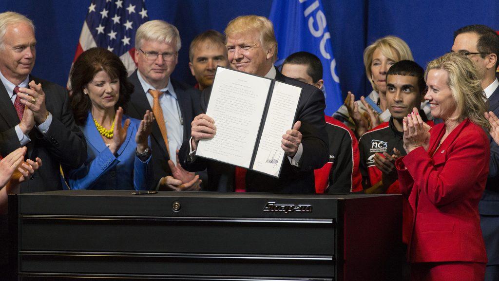 President Donald Trump signs the so-called "Buy American, Hire American" executive order on April 18, 2017, during a visit to Snap-on Inc. in Kenosha, Wis. The orders clamp down on guest worker visas and require federal agencies to buy more goods and services from U.S. companies and workers. (Mark Hoffman/Milwaukee Journal Sentinel/TNS)
