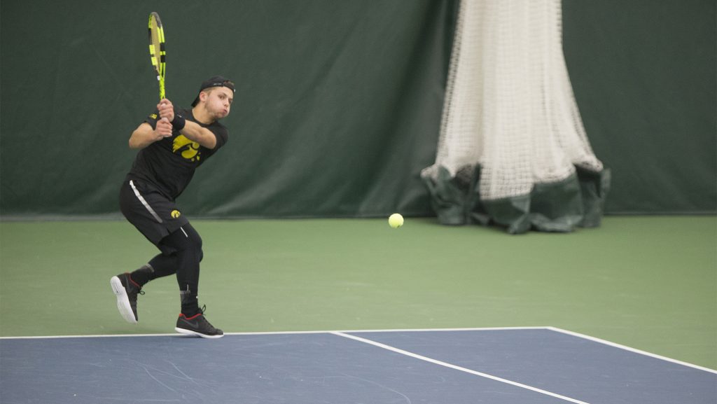 Iowas Will Davies wails a backhand during a tennis match between Iowa and Western Michigan in Iowa City on Friday, Jan. 19, 2018. The Hawkeyes earned the doubles point but lost the match overall, 5-2. (Shivansh Ahuja/The Daily Iowan)