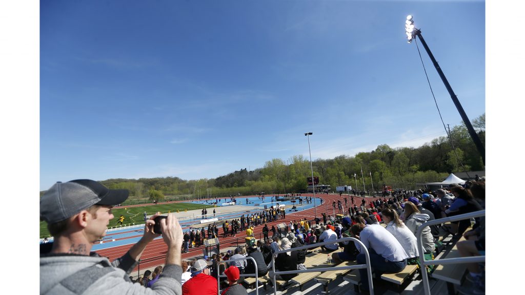 A fan takes a photo of Iowa seniors on the front straightaway during the 18th annual Musco Twilight at Francis X. Cretzmeyer Track on Saturday, April 22, 2017. Iowas men and womens track and field finished first overall in the Musco Twilight with a 237.5 and 203 respectively. (The Daily Iowan/Joseph Cress)