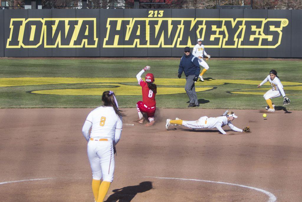 Wisconsin outfielder Brianna Flugaur slides into second base around an Iowa error during the Iowa/Wisconsin softball game at Bob Pearl Field  on Saturday, April 7, 2018. The Hawkeyes defeated the Badgers in the second game of the series, 4-3. (Lily Smith/The Daily Iowan)