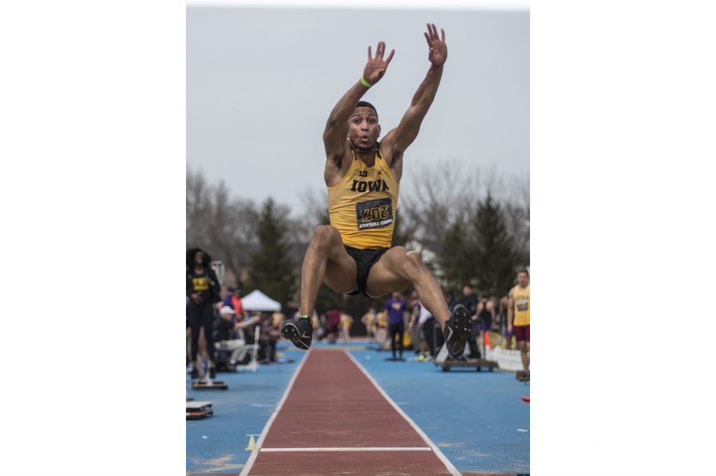 Iowa senior OShea Wilson attempts the long jump during the 19th annual Musco Twilight meet at the Francis X. Cretzmeyer Track in Iowa City on Thursday, April 12. Wilson placed first in the event at 7.50 meters. (Ben Allan Smith/The Daily Iowan)