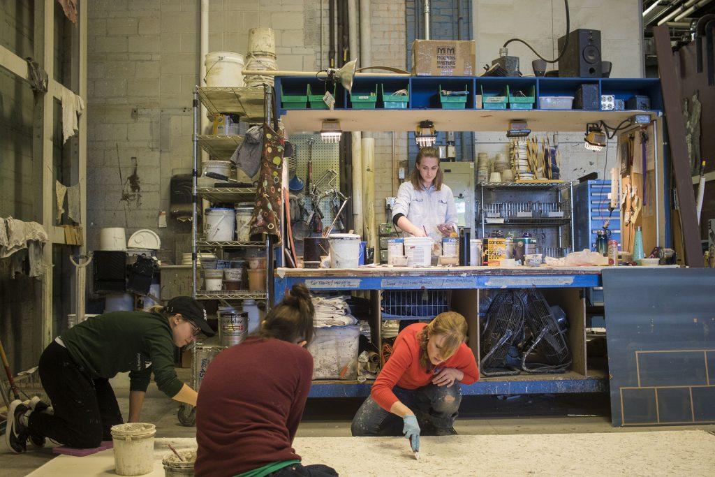 Scenic Charge Artist Kaitin Younger (bottom right) and her team of scenic painters paint sets in the Theatre Building on Thursday, March 29, 2018.