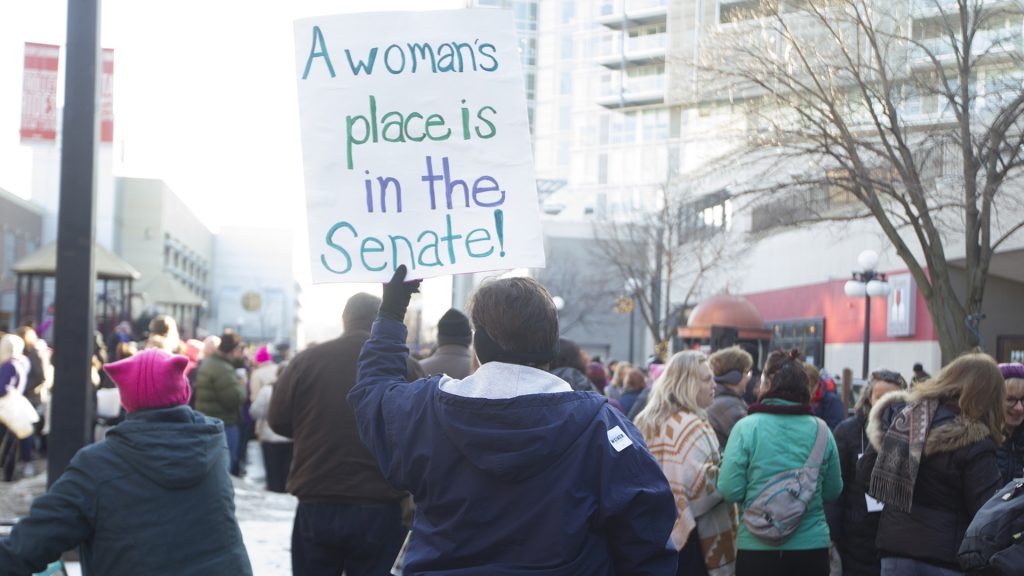A demonstrator holds her sign during the Womens March on January 20, 2018. Hundreds gathered on the Ped Mall to listen to speakers and march for womens rights. (Katie Goodale/The Daily Iowan)