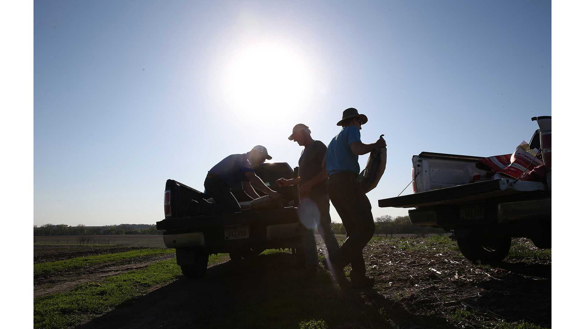 Jon Bakehouse, right, and his father Bach Bakehouse, center, pick up a few bags of a new type of soybean during planting season on April 29,  2015 in Hastings, Iowa. (Abel Uribe/Chicago Tribune/TNS)